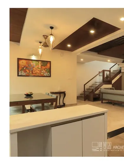 The open-plan living and dining area at our Thalassery residence, where modern furniture and traditional art create a balanced and aesthetically pleasing space.