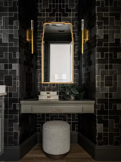 A vanity nook within the powder room, where the 'Fretwork' wallpaper provides a stunning, graphic backdrop. The design's sharp lines and dark tones create a chic and contemporary feel.