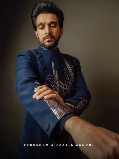 A close-up on the details. Pratik Gandhi adjusts the sleeve of his custom-embroidered bandhgala, a piece designed to be as powerful as the man wearing it.