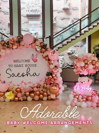 An adorable and grand baby welcome arrangement for Saesha at her Nani's house. The large backdrop with a rose gold and pink balloon arch creates a stunning focal point in the entryway.