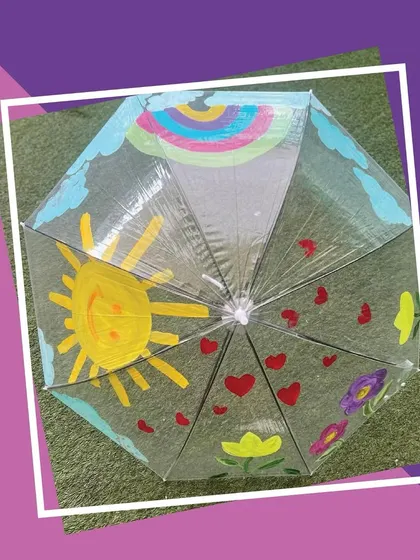The final result of our umbrella painting activity. This colorful creation, full of sunshine and hearts, is ready to brighten up any rainy day. It's a perfect take-home gift.
