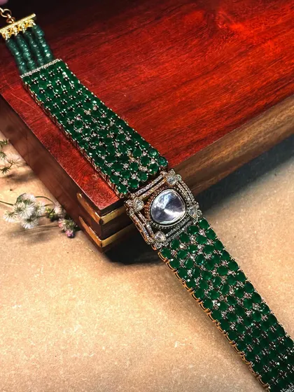A wide choker made of intricately woven green beads with a central polki diamond motif.
