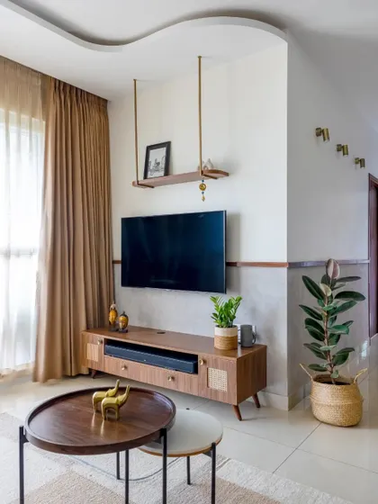 A detail of the living room, showing the suspended shelf above the TV and the textured wall treatment.