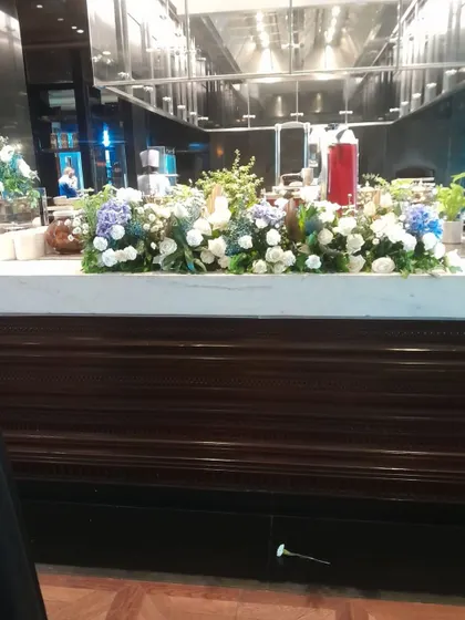 We also provide elegant floral arrangements for event spaces, like this beautiful display of white and blue hydrangeas on a buffet counter, adding a touch of class to the celebration.