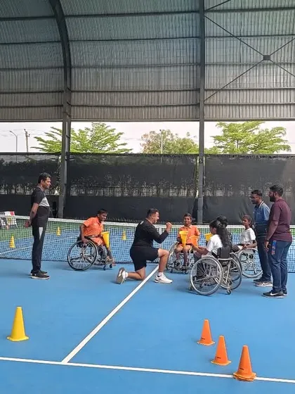 A coach kneels down to connect with young athletes during a workshop, demonstrating our personalized and encouraging approach to teaching.