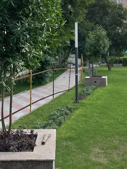 This view shows the integration of lighting posts and stone planters along the community park's edge. Thoughtful placement of these elements is part of my comprehensive landscape design service.