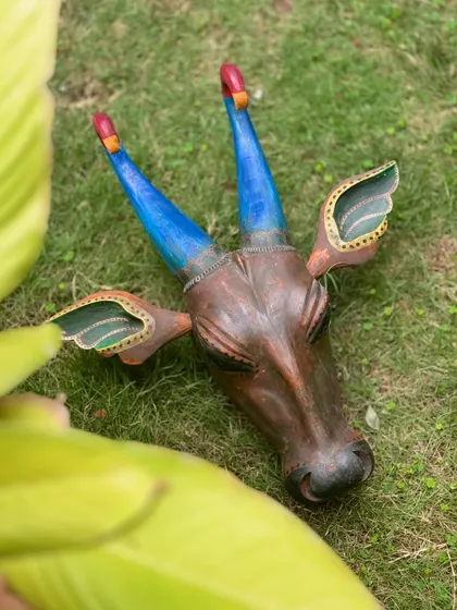 A hand-painted wooden bull head, inspired by the Oachira Cattle Festival in Kerala. The vibrant colors and rustic finish make this an exquisite and culturally rich addition to your festive decor.