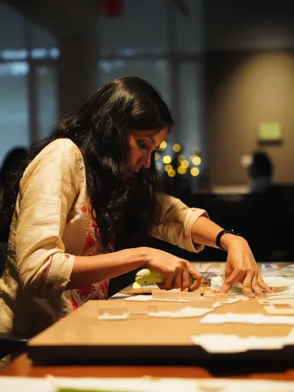 An architect carefully works on a physical model in our studio. Model making is a crucial part of our process, allowing us to test ideas and understand spatial relationships in three dimensions.