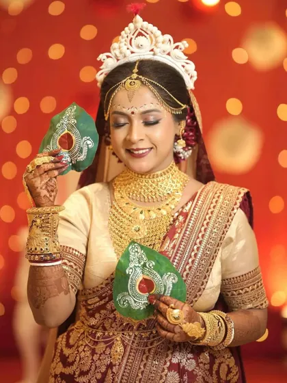 This bride is all smiles, holding her custom-painted paan leaves against a beautiful bokeh background. It's a perfect blend of tradition and personal style.