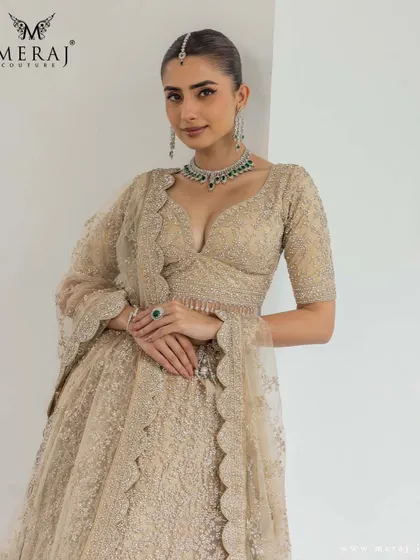 A closer look at the golden lehenga, highlighting the pearl embellishments and intricate thread embroidery that speak of tradition.