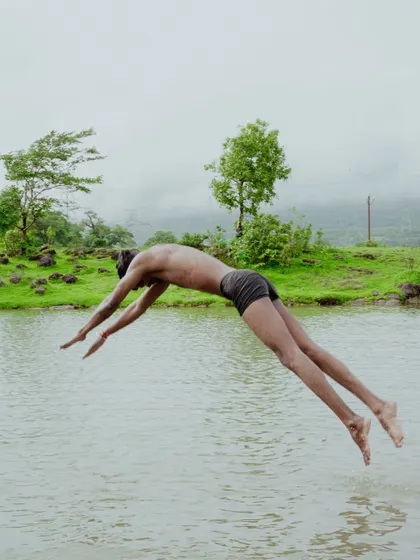 A photo series documenting the vibrant life of Junnar during the monsoon. It includes scenes of children playing, farmers at work, a man diving into a lake, and even a playful monkey.