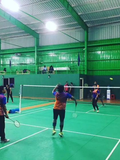 An employee prepares to return a shot during a competitive doubles match. My facility is perfect for capturing the dynamic action of a fast-paced corporate sports day.