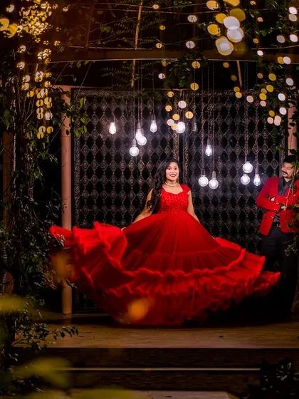 A magical night shot with the bride twirling in her red gown. The combination of the flowing dress and the sparkling lights creates a truly enchanting and cinematic portrait.