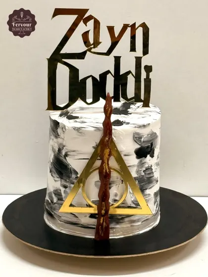 A modern and minimalist Harry Potter cake I made for my son. It features a black and white marbled effect with the Deathly Hallows symbol and a wand, proving that theme cakes can also be very chic.