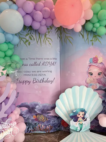 A close-up of the mermaid storybook backdrop, which reads 'Once upon a time there was a little princess called Adya'.