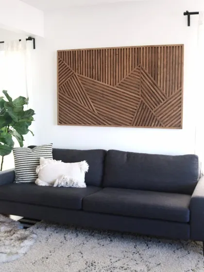 A full view of the geometric stick art in a living room, showing how its large size can command attention and define the style of the room.