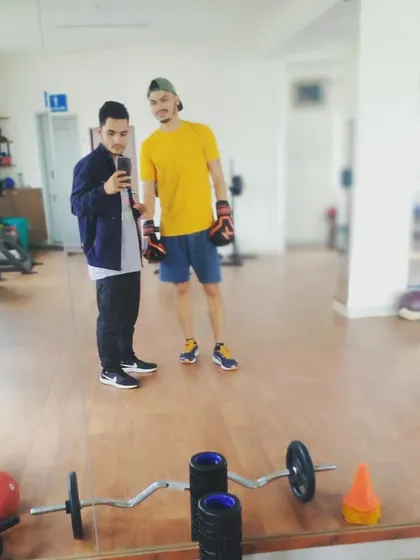 With a client in the gym. The open layout provides ample space for personal training sessions, with access to free weights and other equipment.