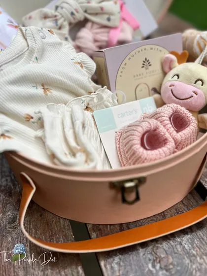A close-up of the contents, showing the textures of the ribbed-knit clothing and the soft, knitted booties, all chosen for their quality and comfort.