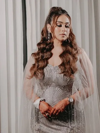 A stunning portrait of the bride in her glamorous silver gown. The soft, even lighting and simple background let her natural beauty and elegant attire shine.