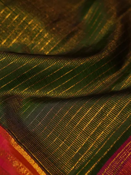 The texture of the gold zari checks on the green silk, a subtle yet luxurious detail.