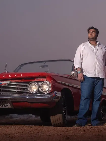 A full shot of the couple with a classic Chevrolet, showcasing the car as a stunning prop for a themed pre-wedding shoot.