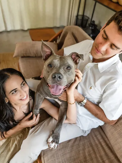 A happy portrait of Millie the Pitbull with her engaged parents. The joy and excitement of this milestone are beautifully reflected in all three of their faces.