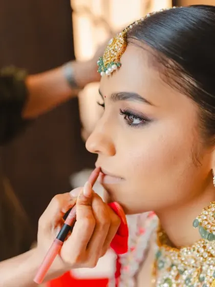 A close-up of the bride getting her final makeup touches. This shot highlights her beautiful features and the careful preparation that goes into the bridal look.