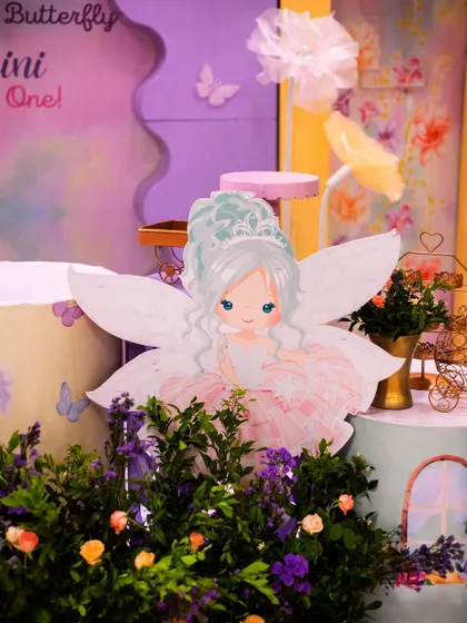 An adorable fairy cutout sitting amongst the flowers. These charming characters are placed throughout the decor to create a sense of a hidden, magical world.