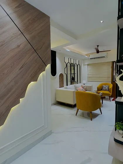 A view from the foyer into the living room, showcasing a custom wall panel with an irregular wooden design and backlighting that creates a dramatic entrance.