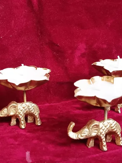 Another view of the elephant urli candles, showcasing the white wax against the golden elephant base.