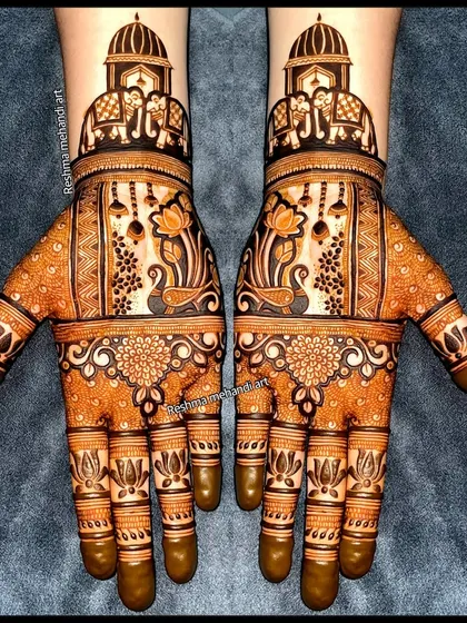 A perfect example of symmetrical bridal mehandi. Both hands mirror each other with designs featuring royal elephants, delicate lotus motifs, and hanging jhumkas, creating a balanced and classic look.