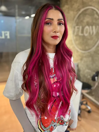 Unleashing her pink power. We combined a brown base with bold pink balayage for a fun, high-contrast look that is full of personality.
