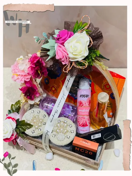 This personalized gift hamper is designed to make her smile. It's a beautiful arrangement of cosmetics from brands like Nykaa and MAC, along with decorative elements.