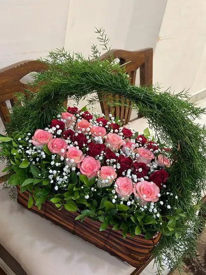Happiness is fresh flowers, and this basket is pure joy. We arranged a beautiful gradient of red and pink roses, dotted with baby's breath, in a rectangular basket with a handle wrapped in fresh greenery.