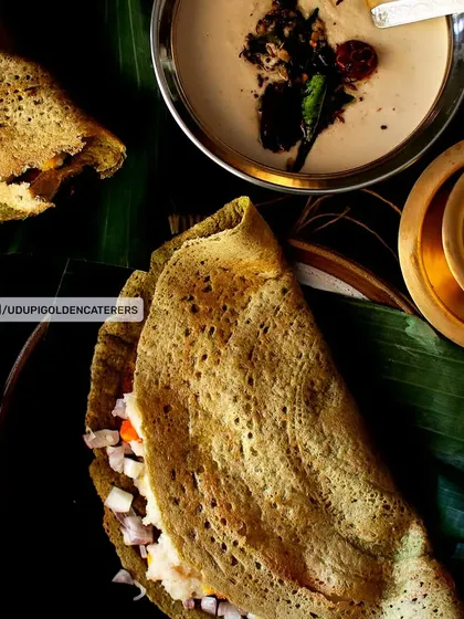 A healthy and flavorful Pesarattu, a savory crepe made from green gram batter. It is shown here filled with chopped onions and served with coconut chutney.