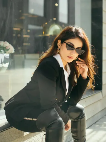 A street style portrait using a shop window for reflections and depth. This shot captures a chic, urban look, blending fashion with the surrounding environment for a candid, magazine-style feel.