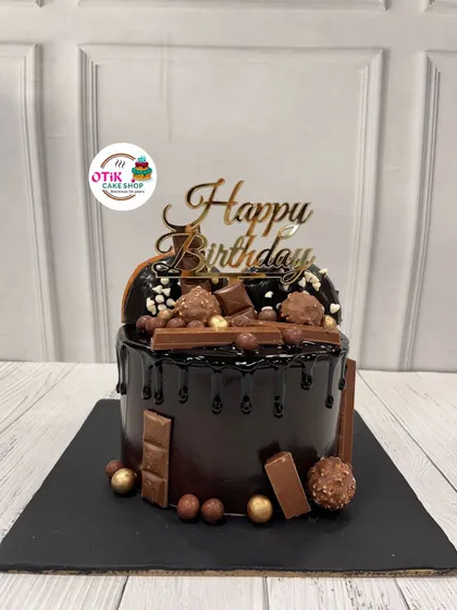 The ultimate chocolate overload cake. This decadent creation is covered in a rich chocolate drip and piled high with Ferrero Rocher, KitKats, and other chocolatey treats.