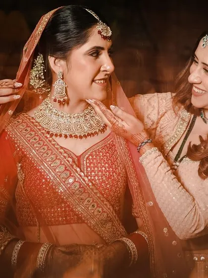 A heartwarming moment between the bride and her sister or friend, who helps her with the final touches. This shot is about the bonds and support system on the wedding day.