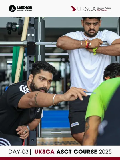 A group of coaches discuss technique during a practical strength training session. This collaborative learning environment is a hallmark of our UKSCA course.