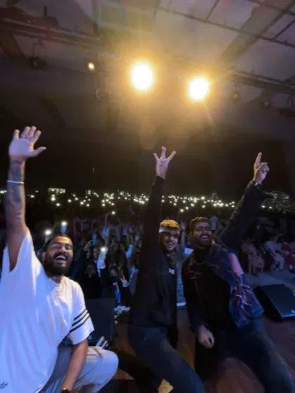 A triumphant moment on stage with my crew at SJPUC, with the audience's flashlights creating a stunning backdrop.