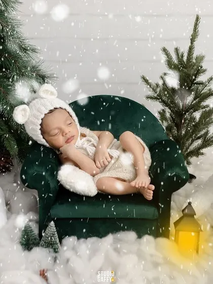A wider view of the winter wonderland setup, with the sleeping baby surrounded by plush polar bears and festive trees.