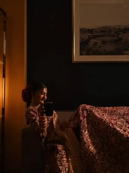 A candid, relaxed moment of the bride taking a break, scrolling on her phone while still in her full wedding attire. It's real and unscripted.