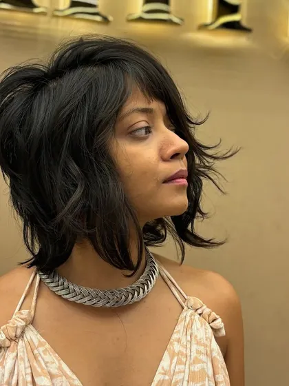 A side view of a textured short haircut, showing how the layers are cut to create volume and a stylish, windswept effect.