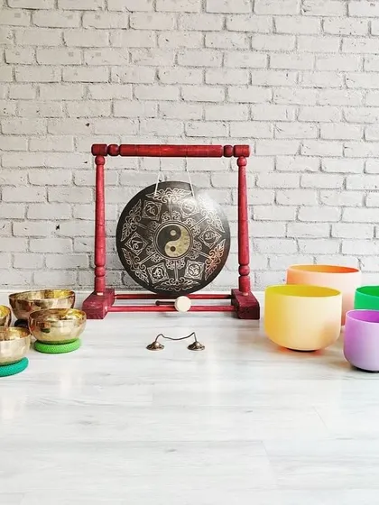 A complete sound bath setup featuring a variety of instruments from our store. This includes colored crystal bowls, Tibetan bowls, and a yin-yang gong, all chosen for their powerful healing properties.