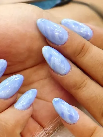 A beautiful and serene design featuring a soft, periwinkle blue marble effect. This look is reminiscent of a cloudy sky or swirling water, creating a calm and elegant manicure.