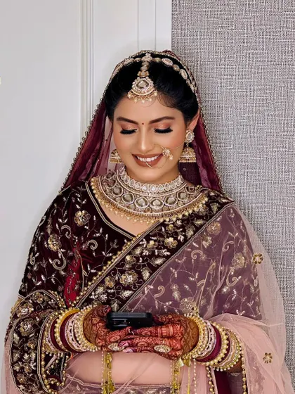 A happy, candid moment of the bride checking her phone. Her makeup is flawless even in a casual moment, showcasing the longevity and finish of the HD makeup I use.