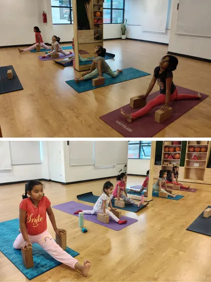 Our students work on their flexibility with Hanumanasana, the splits pose, using blocks for support. We ensure every child progresses at their own pace in a safe and encouraging environment.