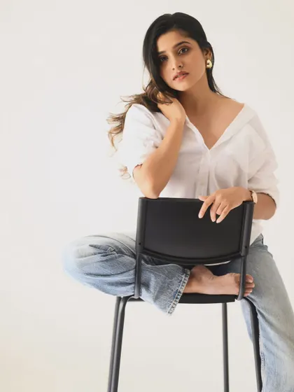 A full-length seated pose that feels relaxed and confident. This is a great example of a simple, effective portfolio shot.