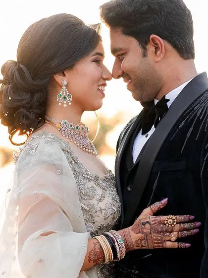 A classic golden hour portrait. The warm, soft light beautifully illuminates the couple, creating a romantic and timeless image.