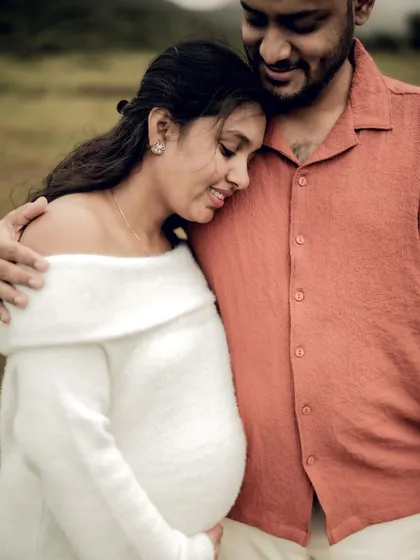 A close-up portrait filled with warmth and tenderness. She leans her head on his chest as he embraces her, a perfect picture of comfort and love.